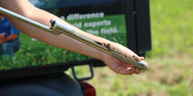 image of a soil sampling technician with a soil probe and soil inside the probe